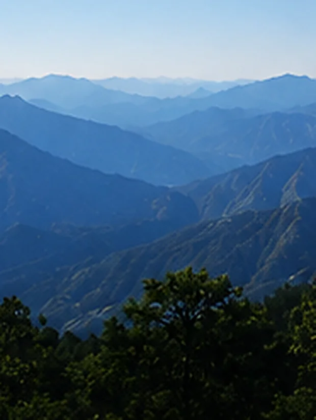 Cordilleras sucesivas de la sierra desvaneciéndose en la bruma azul